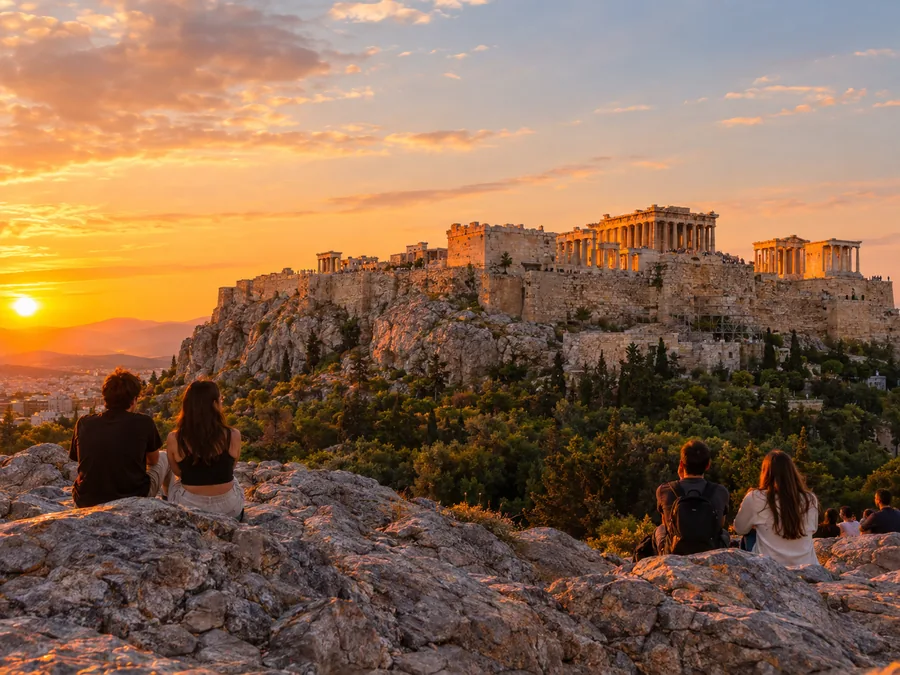 Η Ακρόπολη φωτισμένη από το ηλιοβασίλεμα, όπως φαίνεται από τους βράχους του Αρείου Πάγου